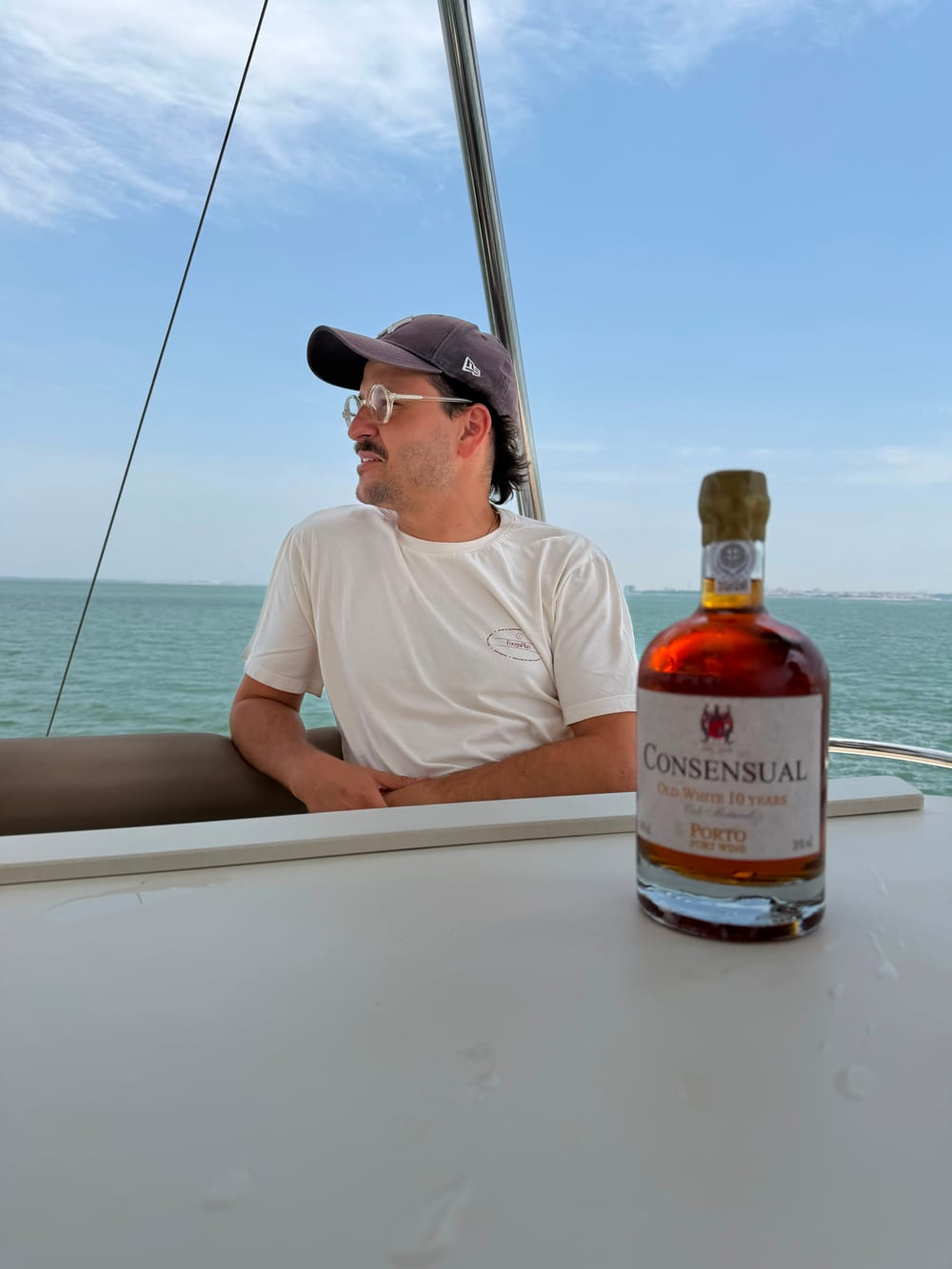 Afonso Girão von Consensual an Bord des Katamarans auf dem Fluss Tejo mit dem Portwein Old White 10 Years und Lissabon im Hintergrund