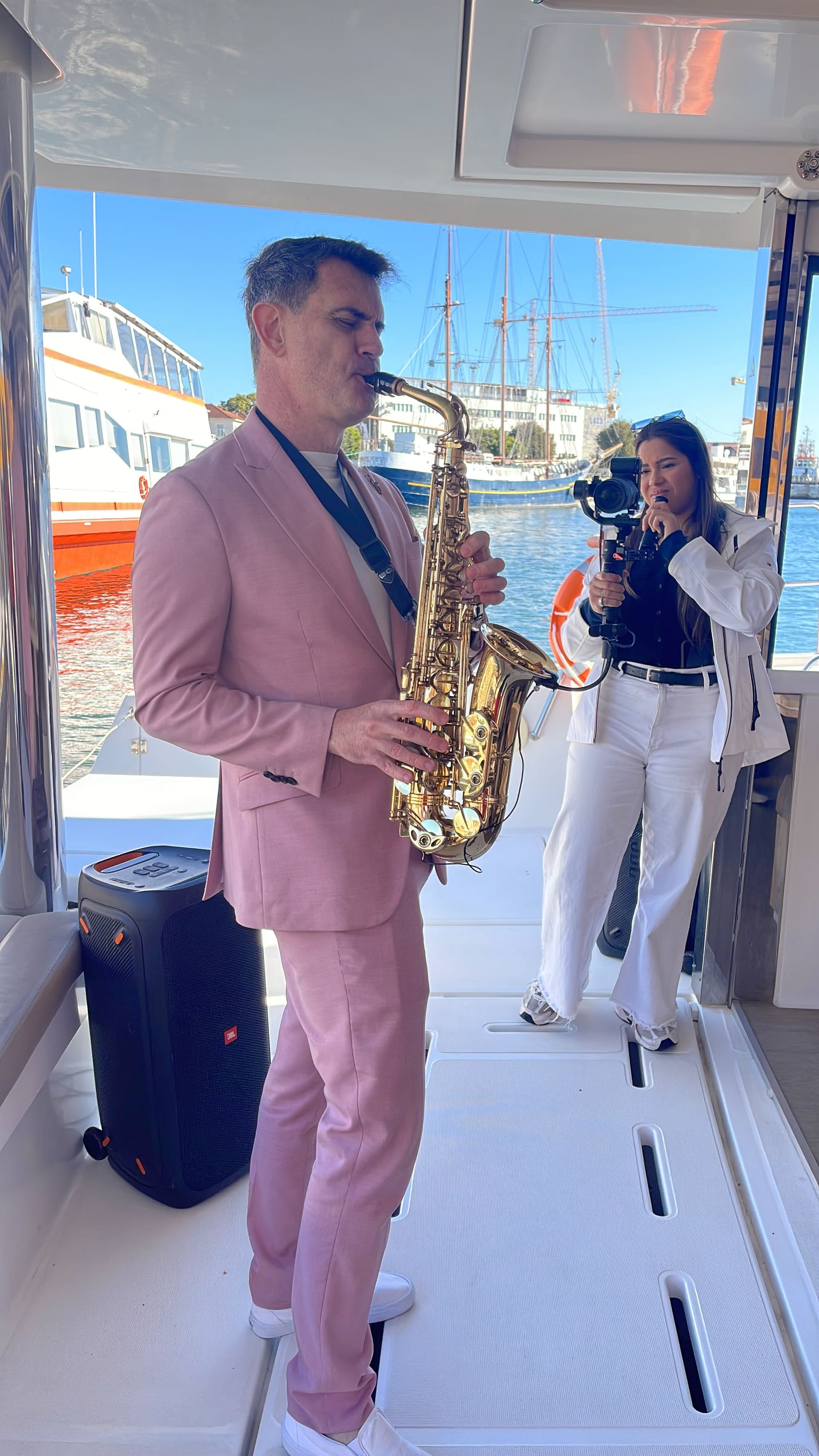Saxofonista a tocar ao vivo a bordo do catamarã, ao pôr-do-sol